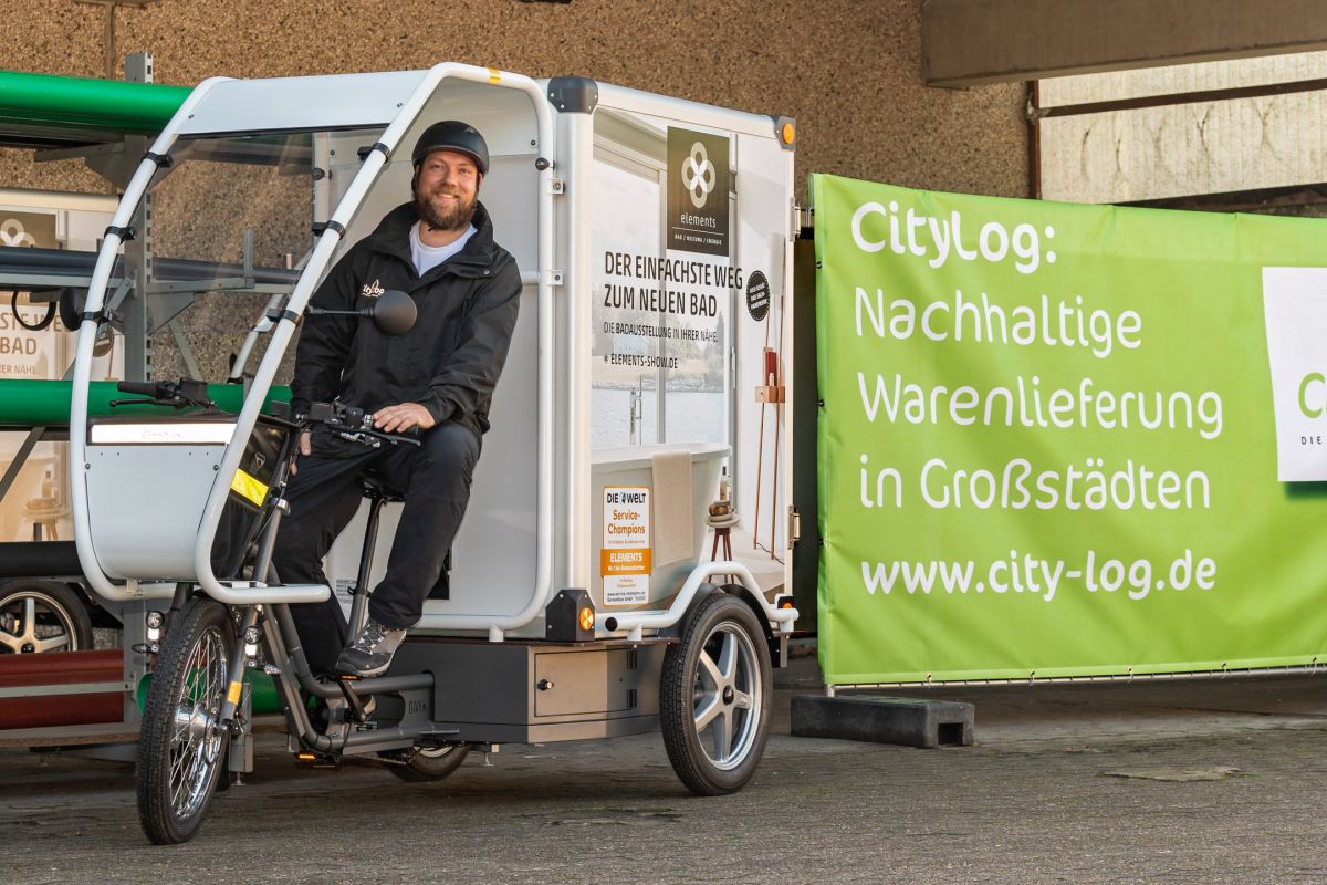 Mann sitzt auf Logistik-Lastenrad
