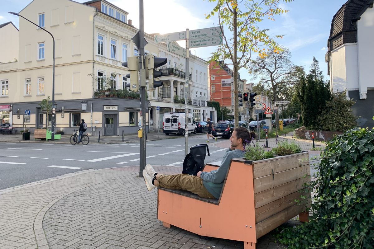 Mann sitzt auf einer bepflanzten Bank an einer Kreuzung in Bremen
